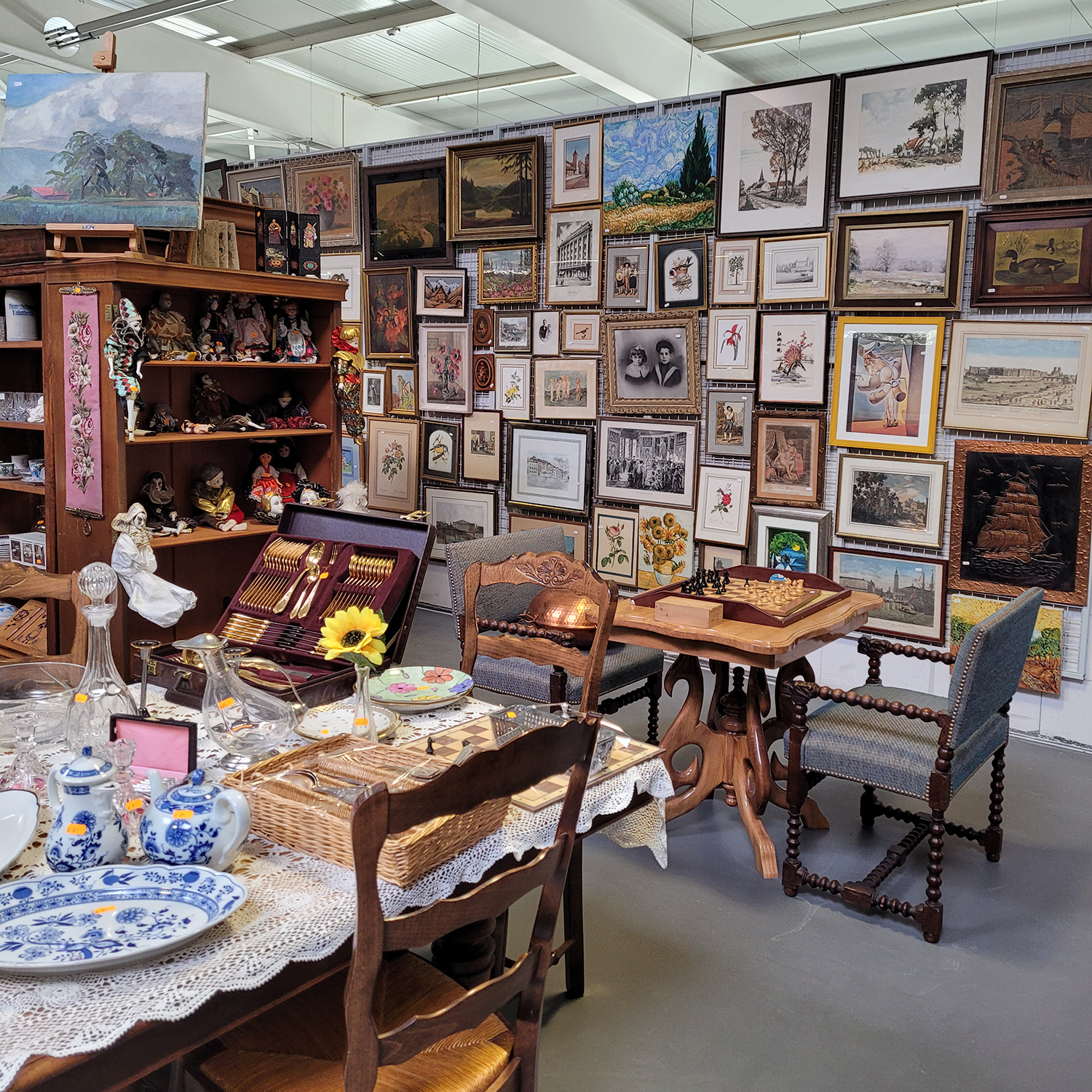 intérieur de la boutique avec de nombreux objets de décoration et des tableaux aux murs décorationvintageGenève articlesdemaisond’occasion brocanteGenève secondevieobjetsGenève achatsolidaireGenève boutiquesecondemainGenève donnerobjetsGenève décod’occasionGenève cadeausolidaireGenève RenfileGenève