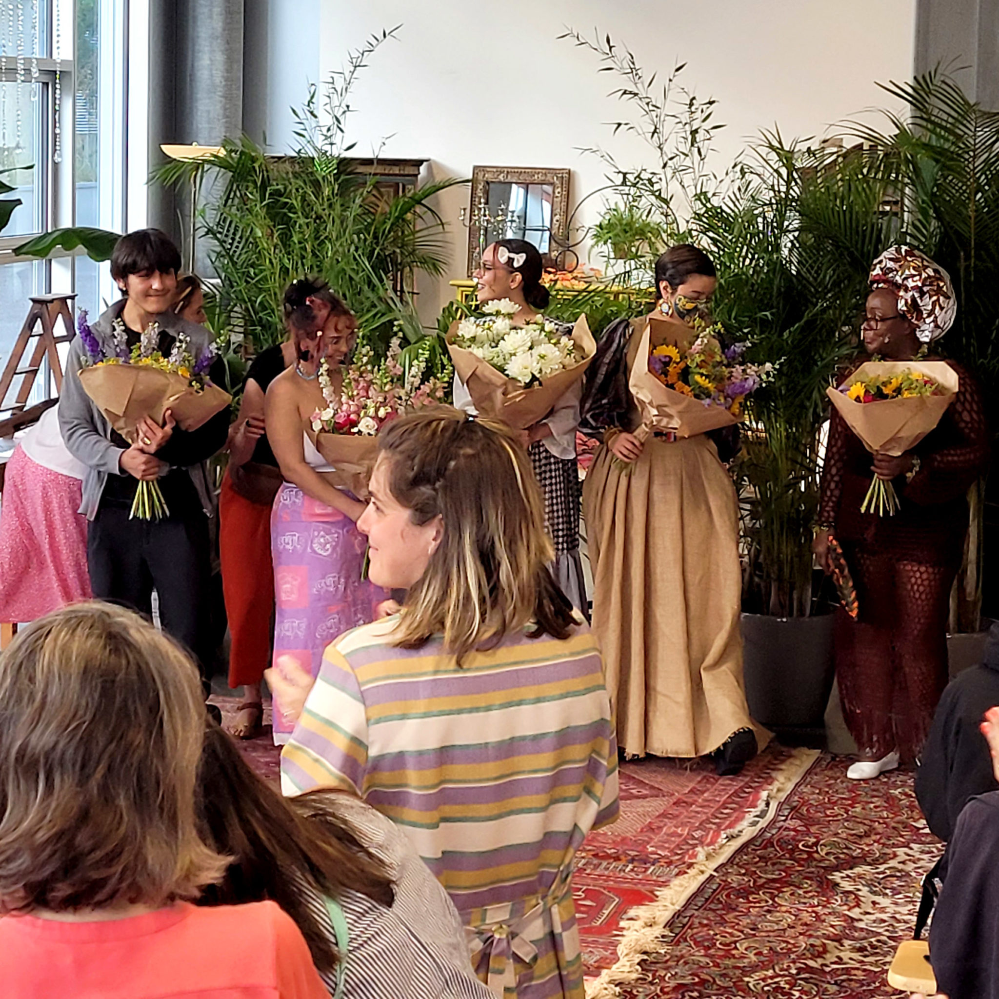 Mannequins recevant des fleurs en hommage à la fin du défilé vêtementssecondemainGenève secondevievêtementsGenève économiecirculaireGenève achatsolidaireGenève boutiquesecondemainGenève friperieGenève donnervêtementsGenève donsolidaireGenève magasinvintageGenève RenfileGenève