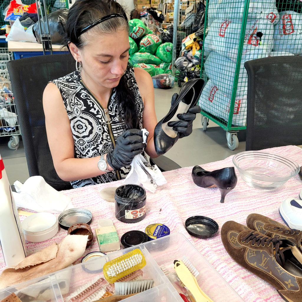 Femme nettoyant et lustrant une chaussure vêtementssecondemainGenève secondevievêtementsGenève friperieGenève boutiquesecondemainGenève achatsolidaireGenève donnervêtementsGenève économiecirculaireGenève donsolidaireGenève magasinvintageGenève RenfileGenève
